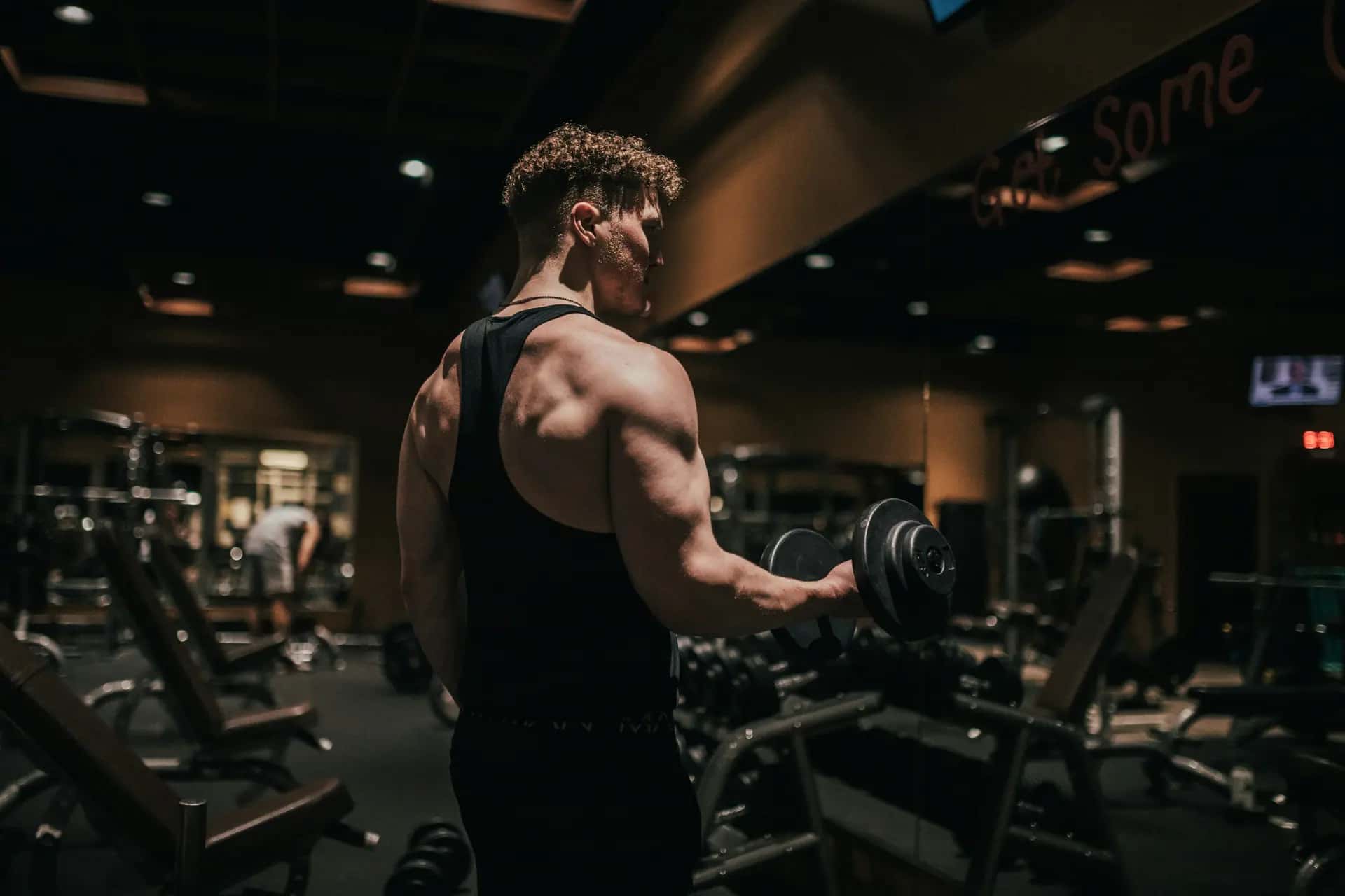 Persona entrenando con mancuernas en un gimnasio